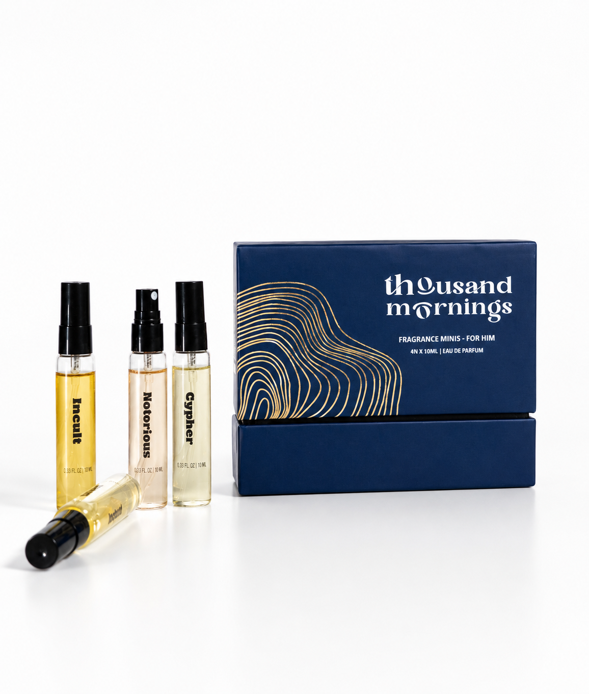 A set of fragrance mini vials and their blue presentation box from Thousand Mornings. The box features gold abstract contour lines and white text reading 'thousand mornings' and 'FRAGRANCE VIALS - FOR 5M'.