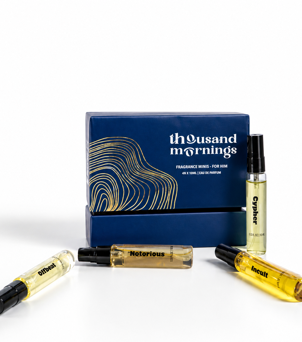 A fragrance gift set from Thousand Mornings, featuring a blue box with gold wave patterns and three clear glass spray vials containing amber-colored liquid, displayed on a clean white background.